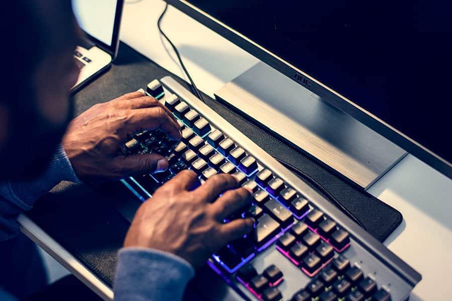 Homem digitando no teclado do computador.